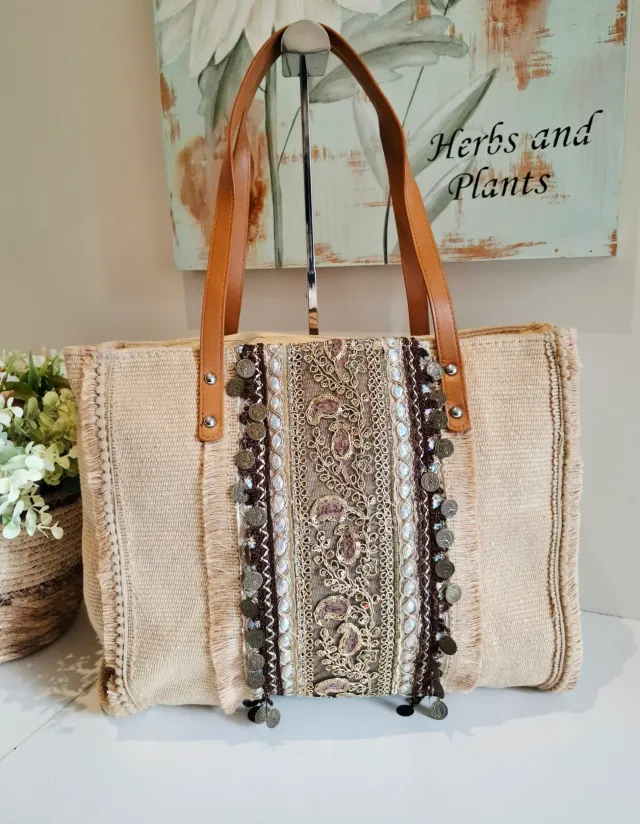Bolso Indu diseño vertical beige con flecos y apliques dorados