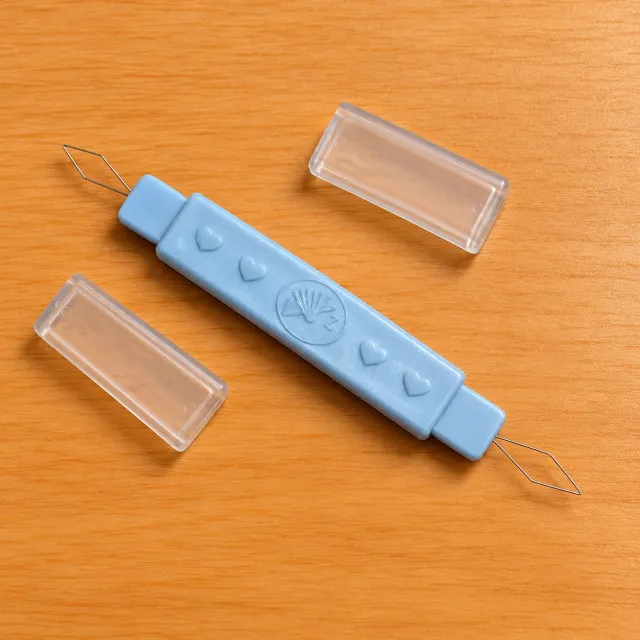 Enhebrador doble de agujas con capuchones protectores
