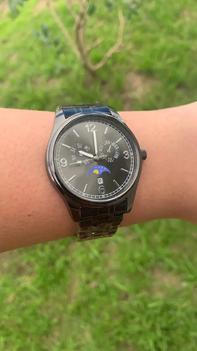 Reloj con brazalete metálico gris oscuro y fases de luna